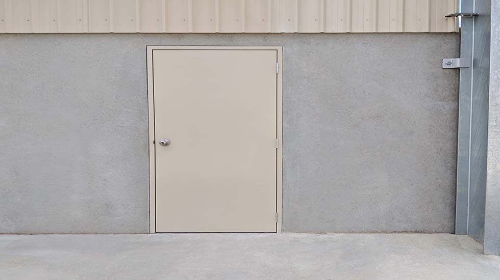 Beige industrial access doors on a warehouse exterior