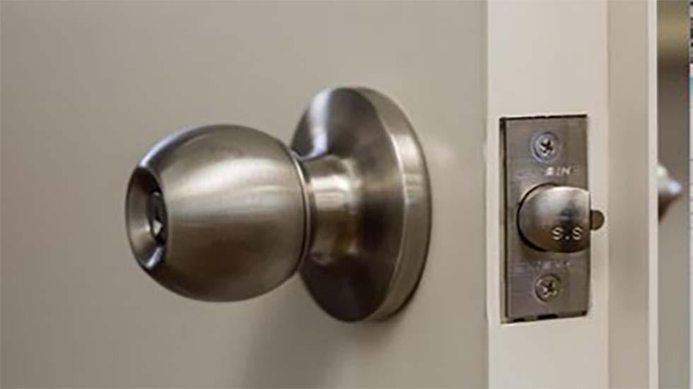 Stainless steel knob lock installed on a personal access door for secure entry