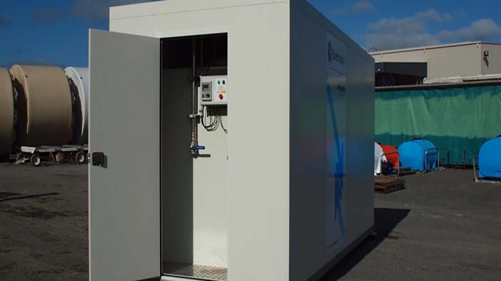 White transportable building with a secure industrial door, suitable for temporary or remote work sites